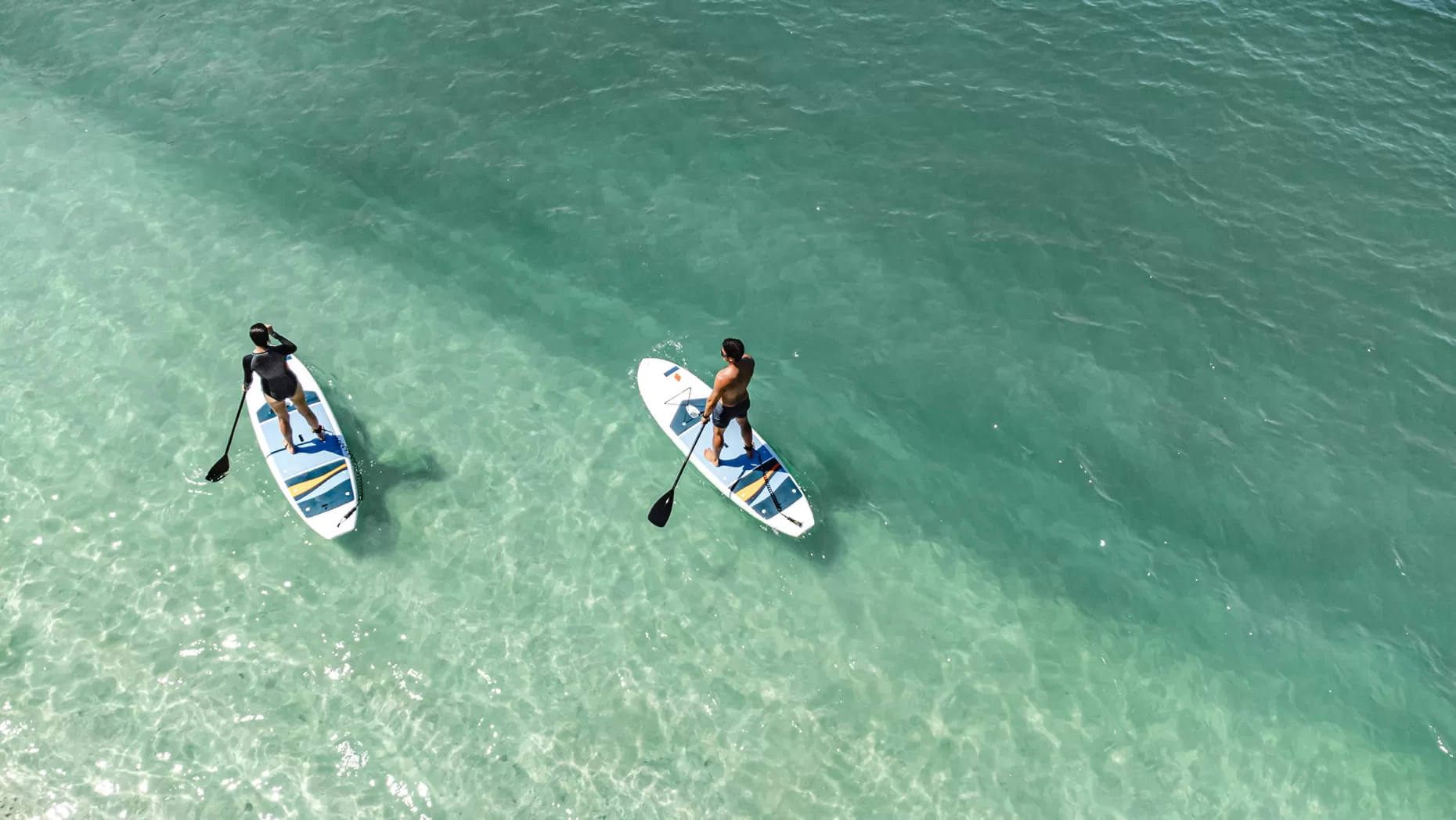 Stand-up paddleboarder gliding over clear water