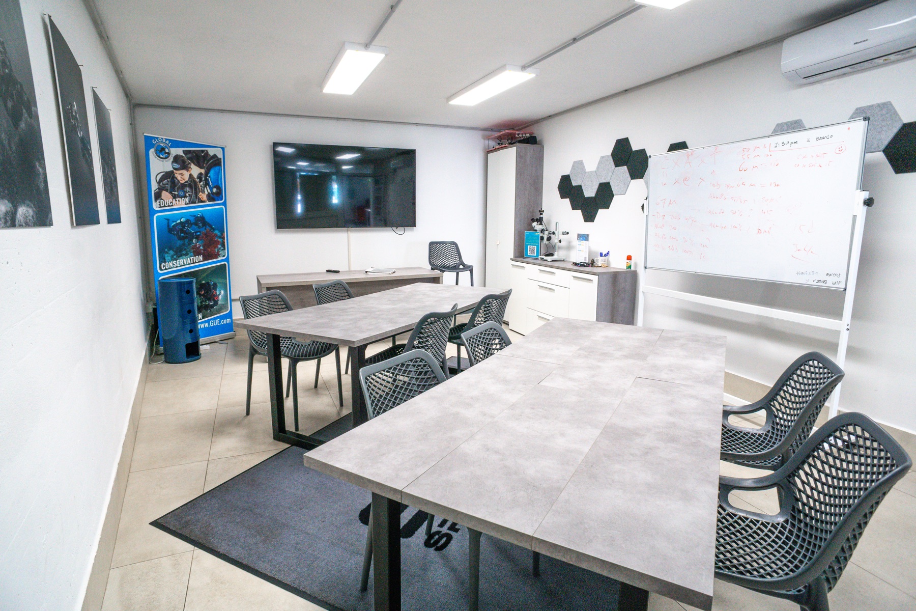Classroom with tables, screen and whiteboard